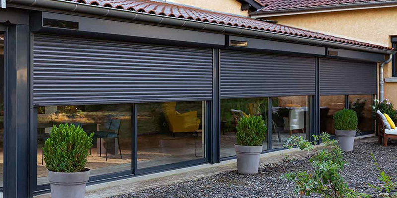 Dunkle Solar Rollladen vor einer Fensterfront